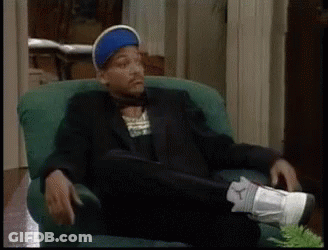 A Man In A Suit Is Sitting In A Chair With His Feet Up GIF