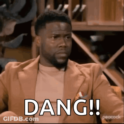A Man In A Suit Is Sitting In A Chair With The Word Dang Written On His Face . GIF