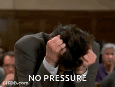 A Man In A Suit Is Sitting In A Courtroom Holding His Head . GIF