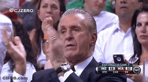 A Man In A Suit Is Sitting In A Crowd Watching A Basketball Game Between Indiana And Miami GIF