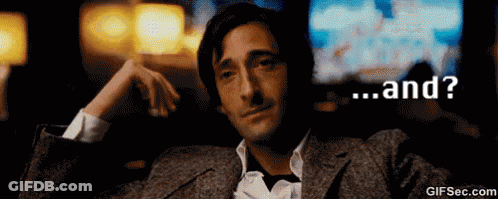 A Man In A Suit Is Sitting In A Dark Room With The Words " And " On The Bottom GIF