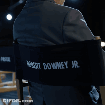 A Man In A Suit Is Sitting In A Director 'S Chair With Pedro Pascal Written On The Back GIF