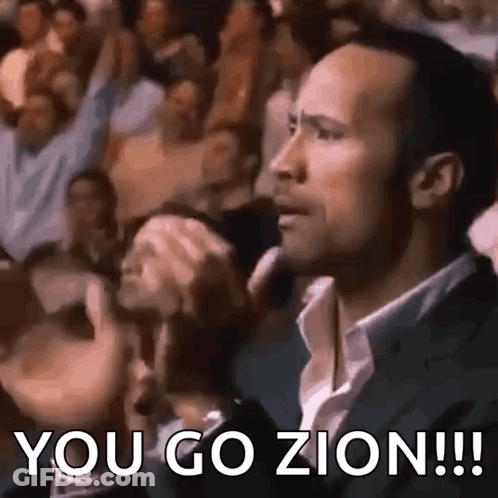 A Man In A Suit Is Sitting In Front Of A Crowd And Saying `` You Go Zion !!! '' GIF