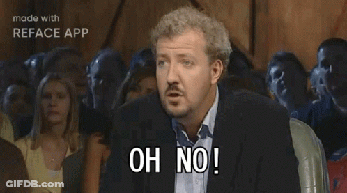 A Man In A Suit Is Sitting In Front Of A Crowd And Says Anyway GIF