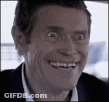 A Man In A Suit Is Smiling And Making A Funny Face In A Car . GIF