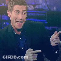 A Man In A Suit Is Smiling And Pointing His Finger GIF