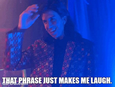 A Man In A Suit Is Smiling And Says That Phrase Just Makes Me Laugh . GIF