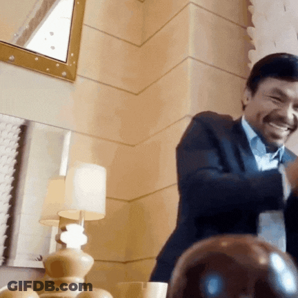 A Man In A Suit Is Smiling In Front Of A Mirror And Lamp GIF
