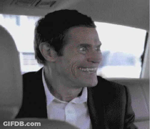 A Man In A Suit Is Smiling While Sitting In The Back Seat Of A Car GIF