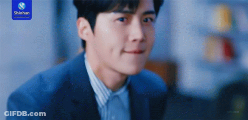 A Man In A Suit Is Smiling With A Shinhan Logo In The Background GIF