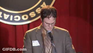 A Man In A Suit Is Speaking Into A Microphone In Front Of A Sign That Says " Social " GIF