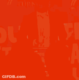 A Man In A Suit Is Speaking Into A Microphone In Front Of A Sign That Says ' Turn Point ' GIF