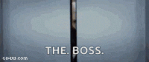 A Man In A Suit Is Standing In A Doorway With The Words The Boss Written On It . GIF