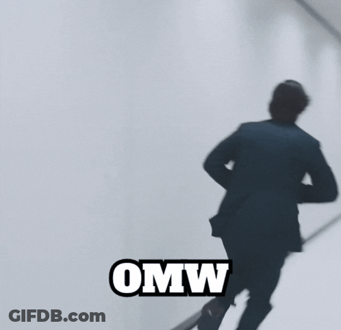 A Man In A Suit Is Standing In A Hallway And The Word Omw Is On The Bottom GIF