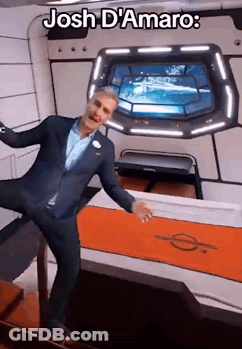 A Man In A Suit Is Standing In A Room With The Words Josh D' Amaro On The Bottom GIF