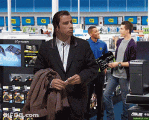 A Man In A Suit Is Standing In A Store Looking At Something GIF
