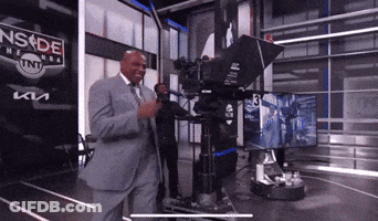 A Man In A Suit Is Standing In Front Of A Camera With A Sign That Says Nsde On It GIF