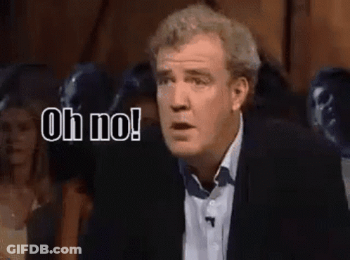 A Man In A Suit Is Standing In Front Of A Crowd And Saying Oh No ! GIF