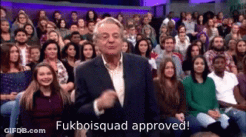 A Man In A Suit Is Standing In Front Of A Crowd . GIF