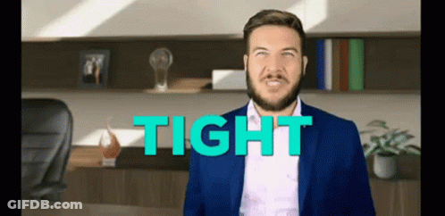 A Man In A Suit Is Standing In Front Of A Desk With The Word Tight Behind Him . GIF