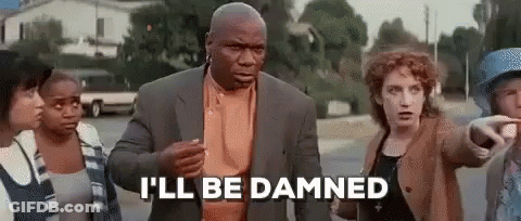 A Man In A Suit Is Standing In Front Of A Group Of People And Talking To Them . GIF