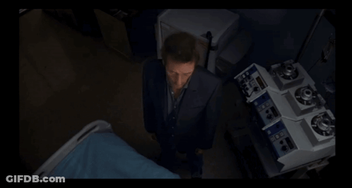 A Man In A Suit Is Standing In Front Of A Machine That Says ' A ' On It GIF