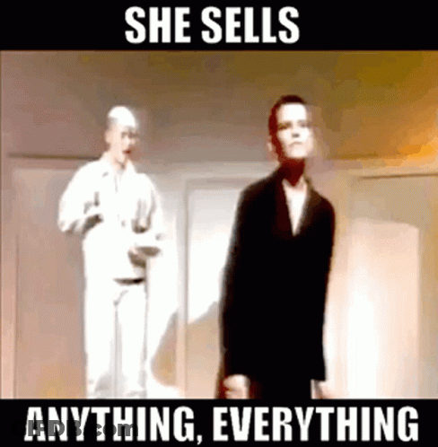 A Man In A Suit Is Standing In Front Of A Man In A White Shirt With The Words She Sells Anything Everything Below Him GIF