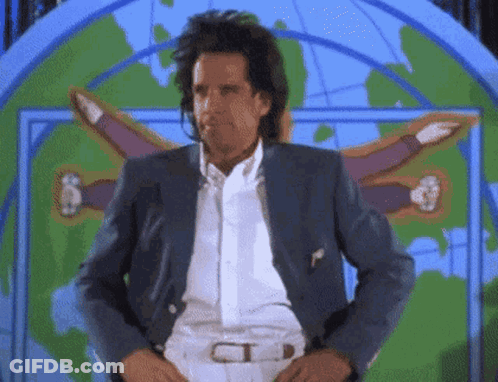 A Man In A Suit Is Standing In Front Of A Map Of The World GIF
