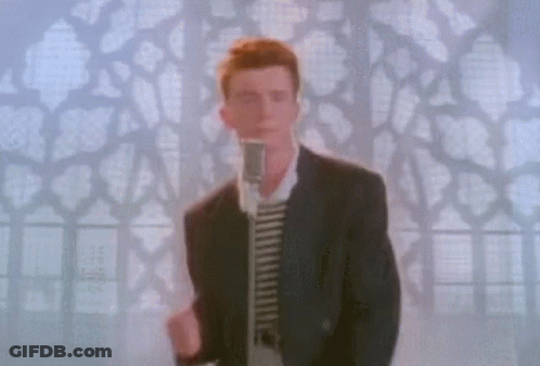 A Man In A Suit Is Standing In Front Of A Microphone . GIF
