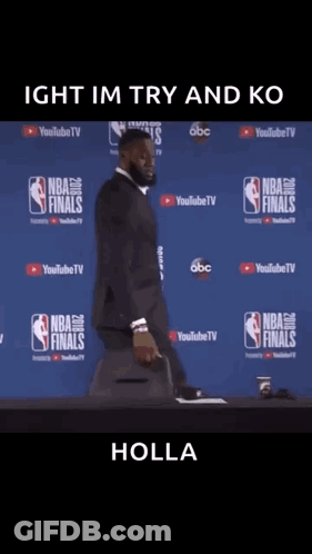 A Man In A Suit Is Standing In Front Of A Nba Finals Wall GIF