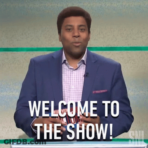 A Man In A Suit Is Standing In Front Of A Podium And Saying Welcome To The Show GIF
