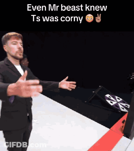 A Man In A Suit Is Standing In Front Of A Sign That Says Even Mr Beast Knew Ts Was Corny . GIF