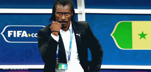 A Man In A Suit Is Standing In Front Of A Sign That Says Fifa GIF