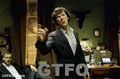 A Man In A Suit Is Standing In Front Of A Sign That Says Gtfo On It GIF