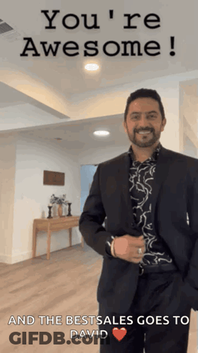 A Man In A Suit Is Standing In Front Of A Sign That Says " You 'Re Awesome " GIF