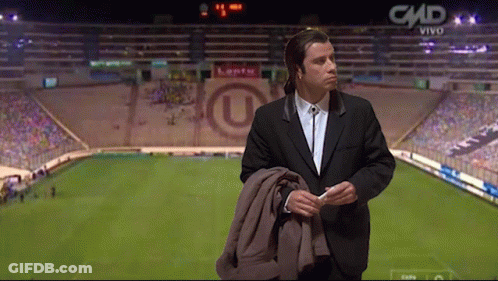 A Man In A Suit Is Standing In Front Of A Stadium That Says Cmd On The Bottom GIF