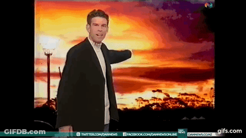 A Man In A Suit Is Standing In Front Of A Sunset With A Twitter And Facebook Icon GIF