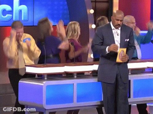 A Man In A Suit Is Standing In Front Of A Table With A Sign That Says ' Ch ' On It GIF