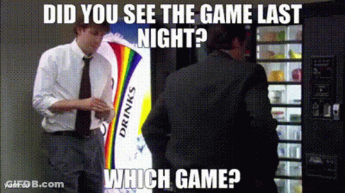 A Man In A Suit Is Standing In Front Of A Vending Machine That Says Drinks On It GIF