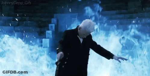 A Man In A Suit Is Standing In Front Of A Wall Of Fire And Water . GIF