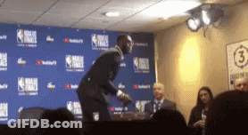A Man In A Suit Is Standing In Front Of A Wall With The Number 3 On It GIF