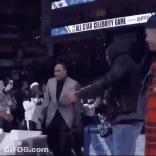 A Man In A Suit Is Standing In Front Of An All Star Celebrity Game Sign GIF