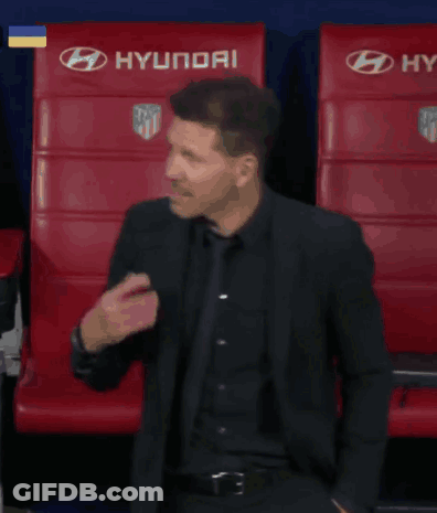 A Man In A Suit Is Standing In Front Of Red Seats GIF