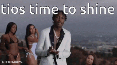 A Man In A Suit Is Standing In Front Of Three Bikinis . GIF