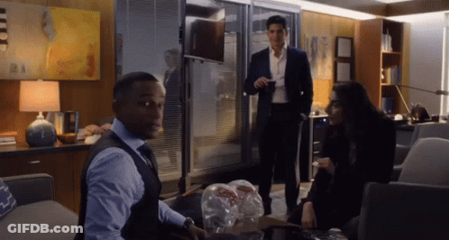 A Man In A Suit Is Standing Next To A Woman In A Black Dress GIF