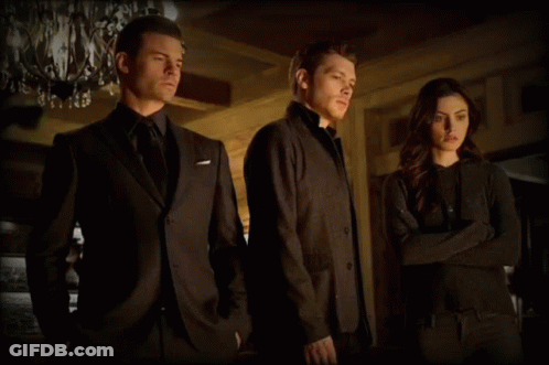 A Man In A Suit Is Standing Next To A Woman GIF