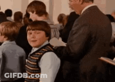 A Man In A Suit Is Standing Next To A Young Boy In A Crowd Of People . GIF