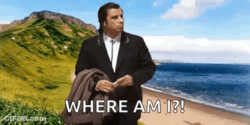 A Man In A Suit Is Standing On A Beach With The Words Where Am I ? Written Below Him GIF