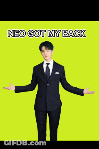 A Man In A Suit Is Standing With His Arms Outstretched And The Words Neo Got My Back Below Him GIF