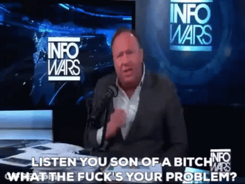 A Man In A Suit Is Talking Into A Microphone In Front Of A Sign That Says Info Wars GIF